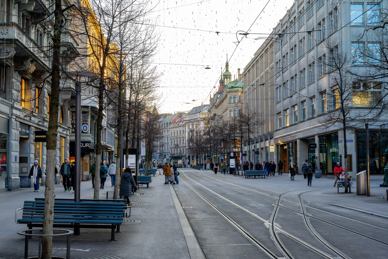A lively street view of Bahnhofstrasse in Zurich, Switzerland, featuring pedestrians and iconic architecture.